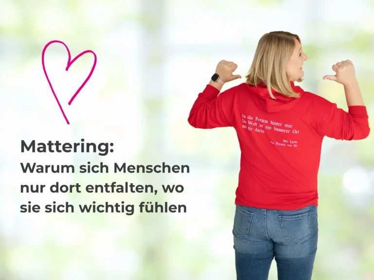 Mattering - Kommunikationstrainerin Sandra Richter in einem Pullover mit einer Aufschrift auf dem Rücken: "An die Person hinter mir. Die Welt ist ein besserer Ort mit dir drin. Die Person vor dir"